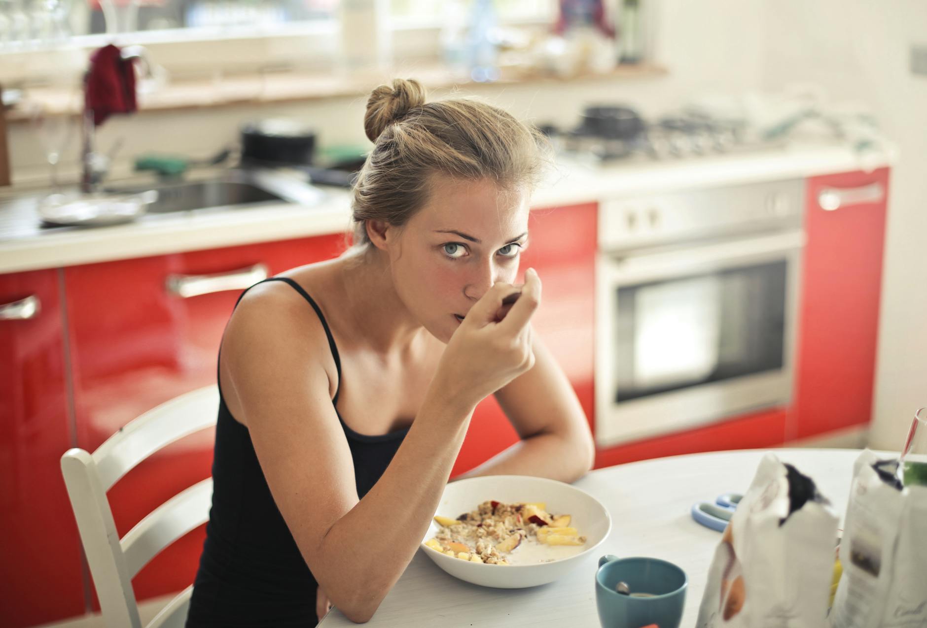 woman in black tank top eating cereals
